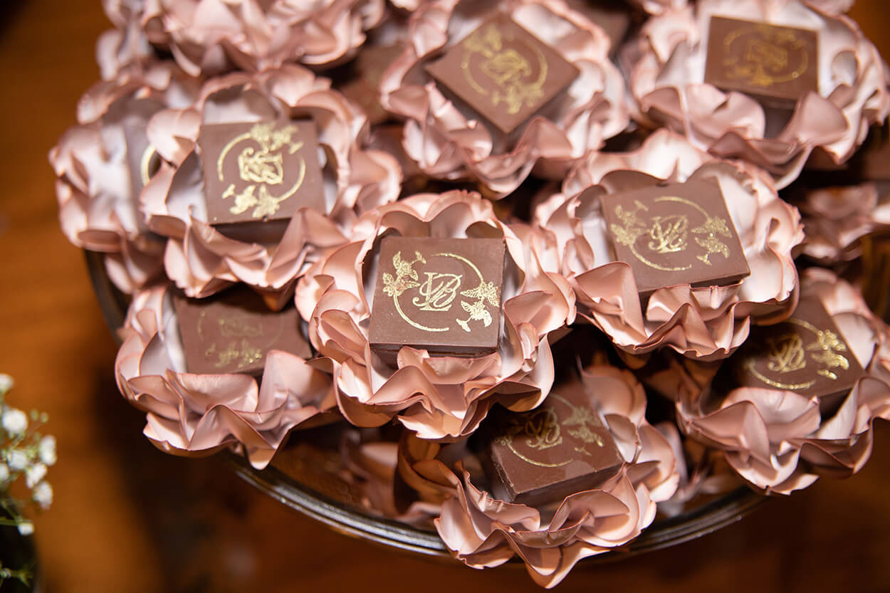 bandeja com doces de casamento de chocolate com forminhas de flores cor de rosa