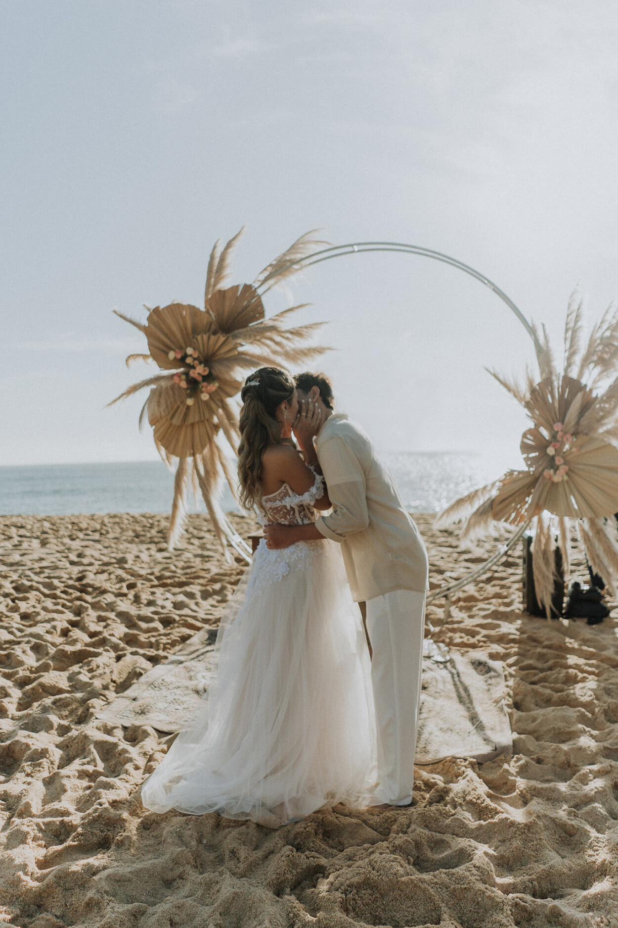 noivos se beijando no casamento na praia