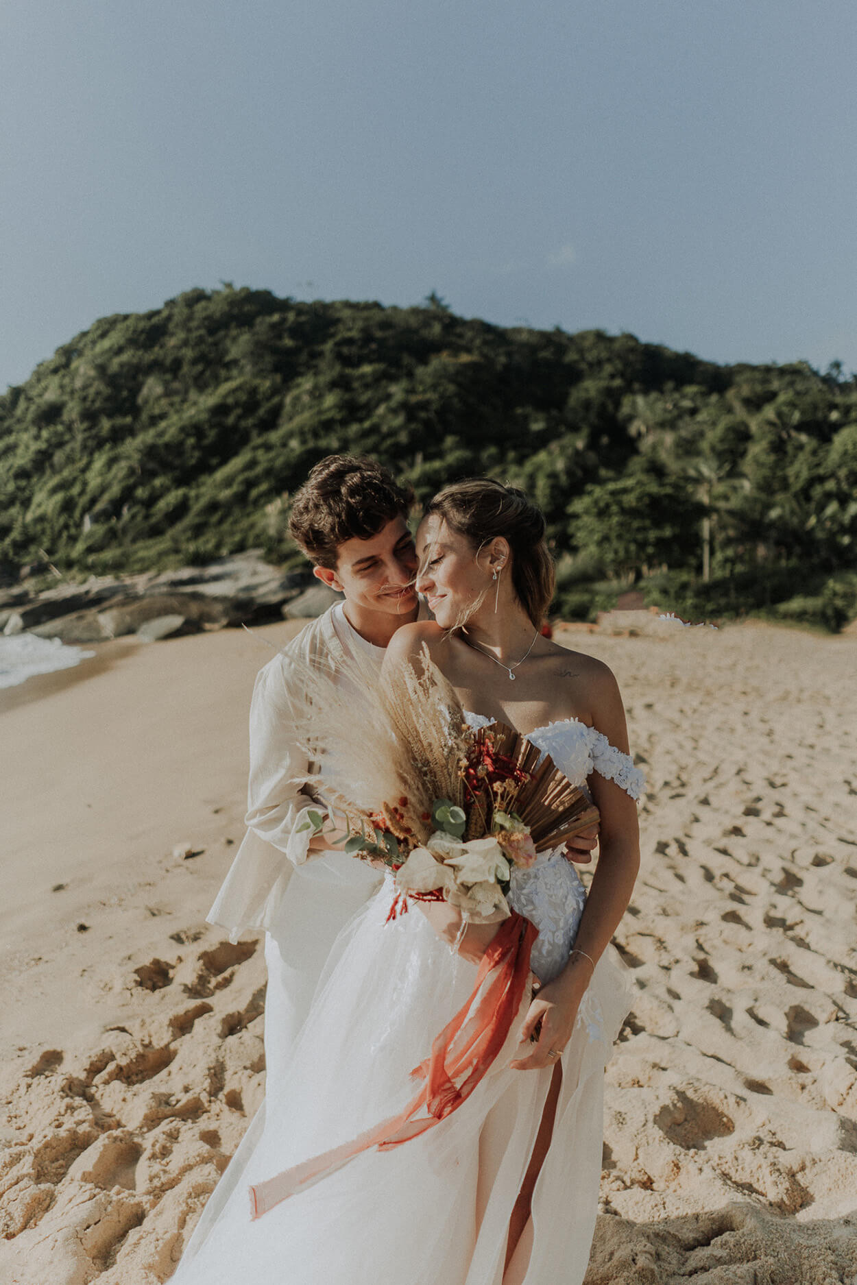 noivos abraçados na praia