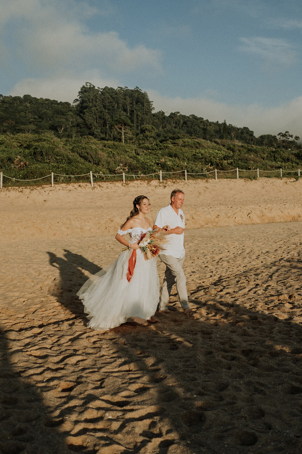 entrada da noiva com o pai no casamento na praia