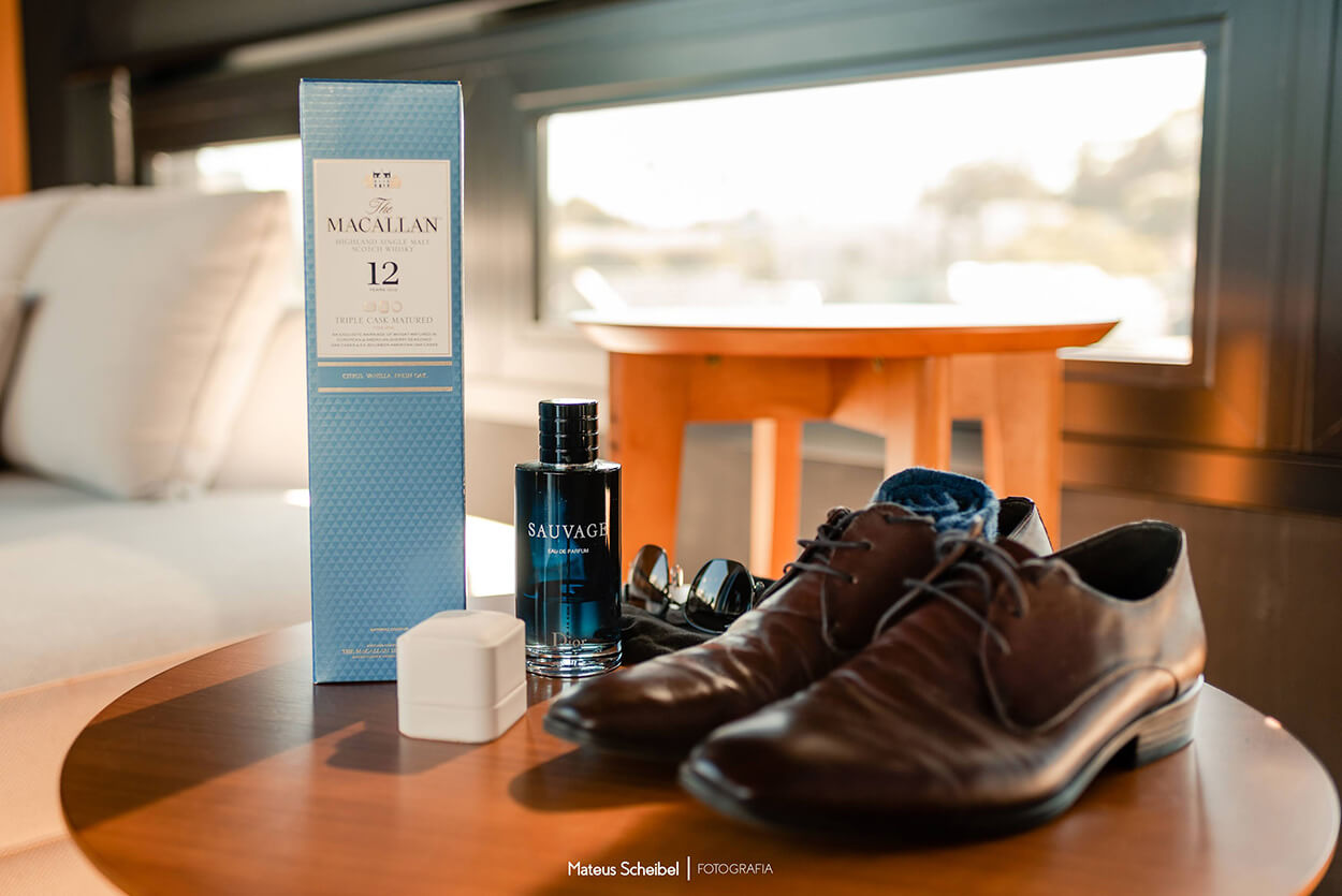 Sapato social marrom ao lado de perfume na mesa