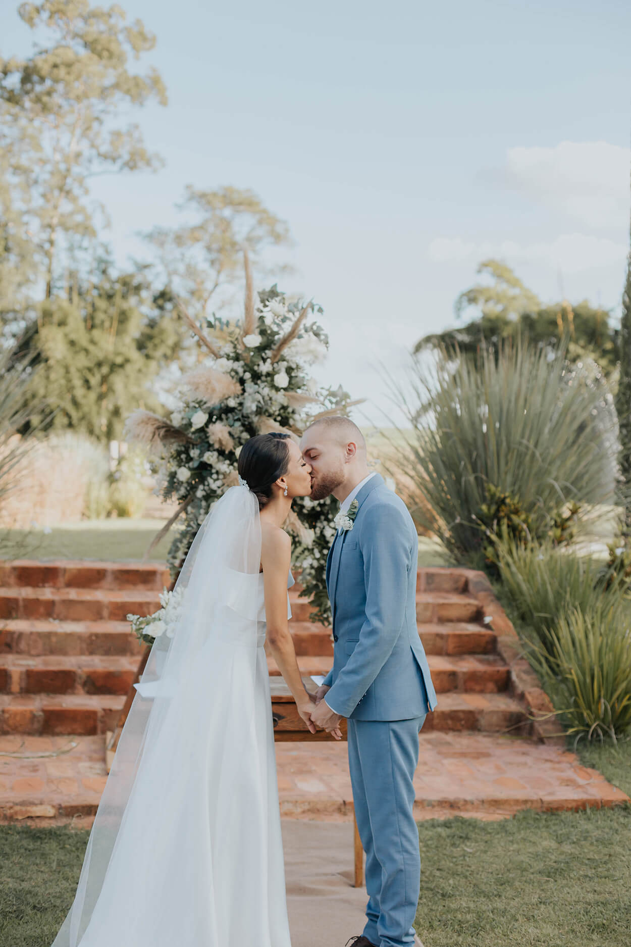 noivos se beijando no altar em casamento ao ar livre