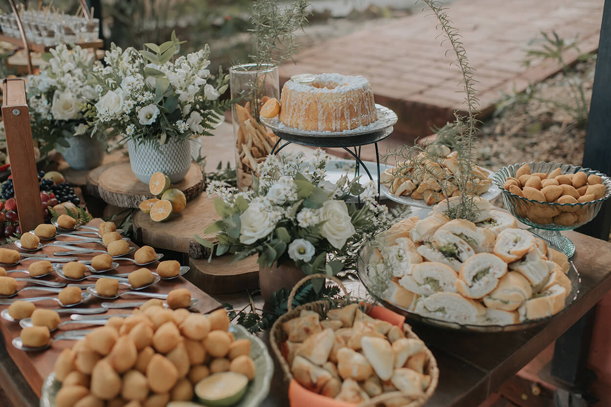 mesa ao ar livre com bolo, pães e doces