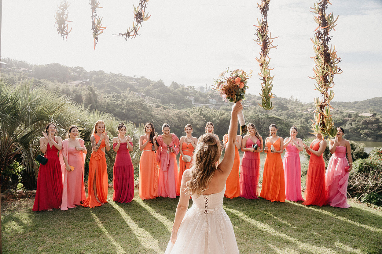 madrinhas com vestidos rosa e laranja vendo a noiva pela primeira vez