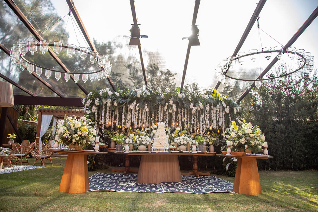 mesa com bolo de casamento branco clássico vasos com flores