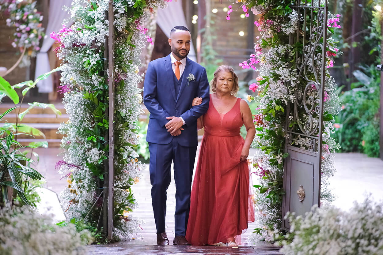 entrada do noivo ao lado da mãe com vestido vermelho