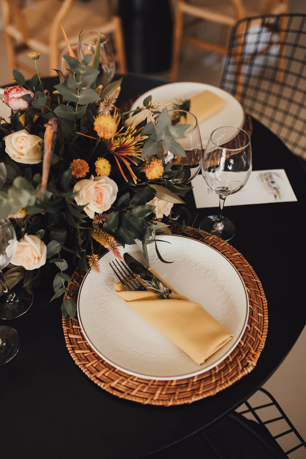 mesa posta com flores brancas e amarelas no centro e sousplat de cime e guardanapo de tecido amarelo
