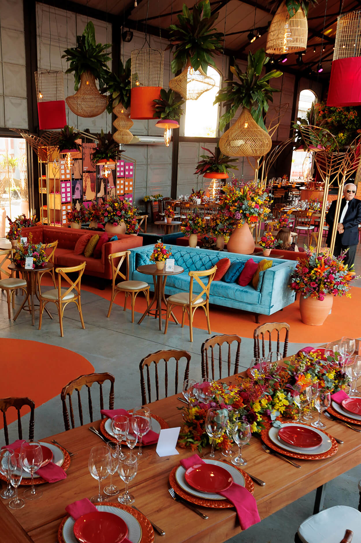 salão com sofá azul e mesa posta com flores coloridas