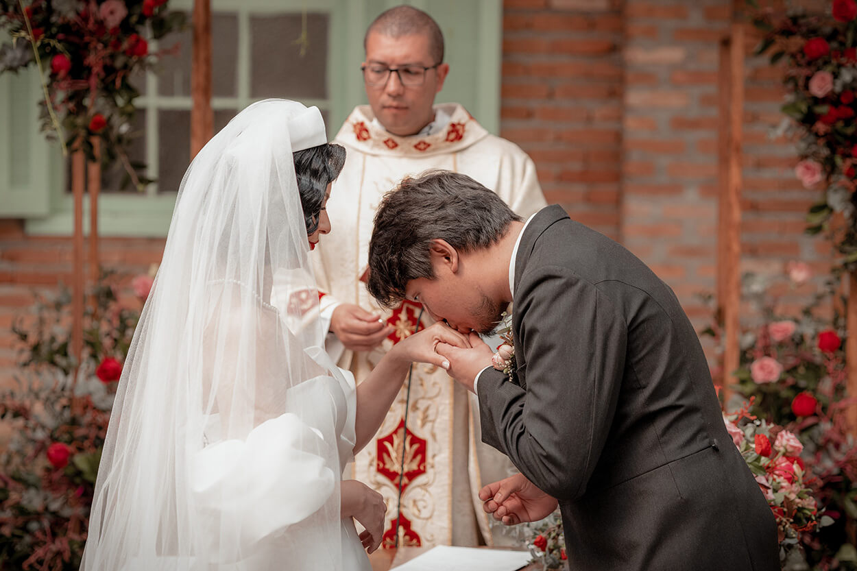 noivo beijando a mão da noiva no altar