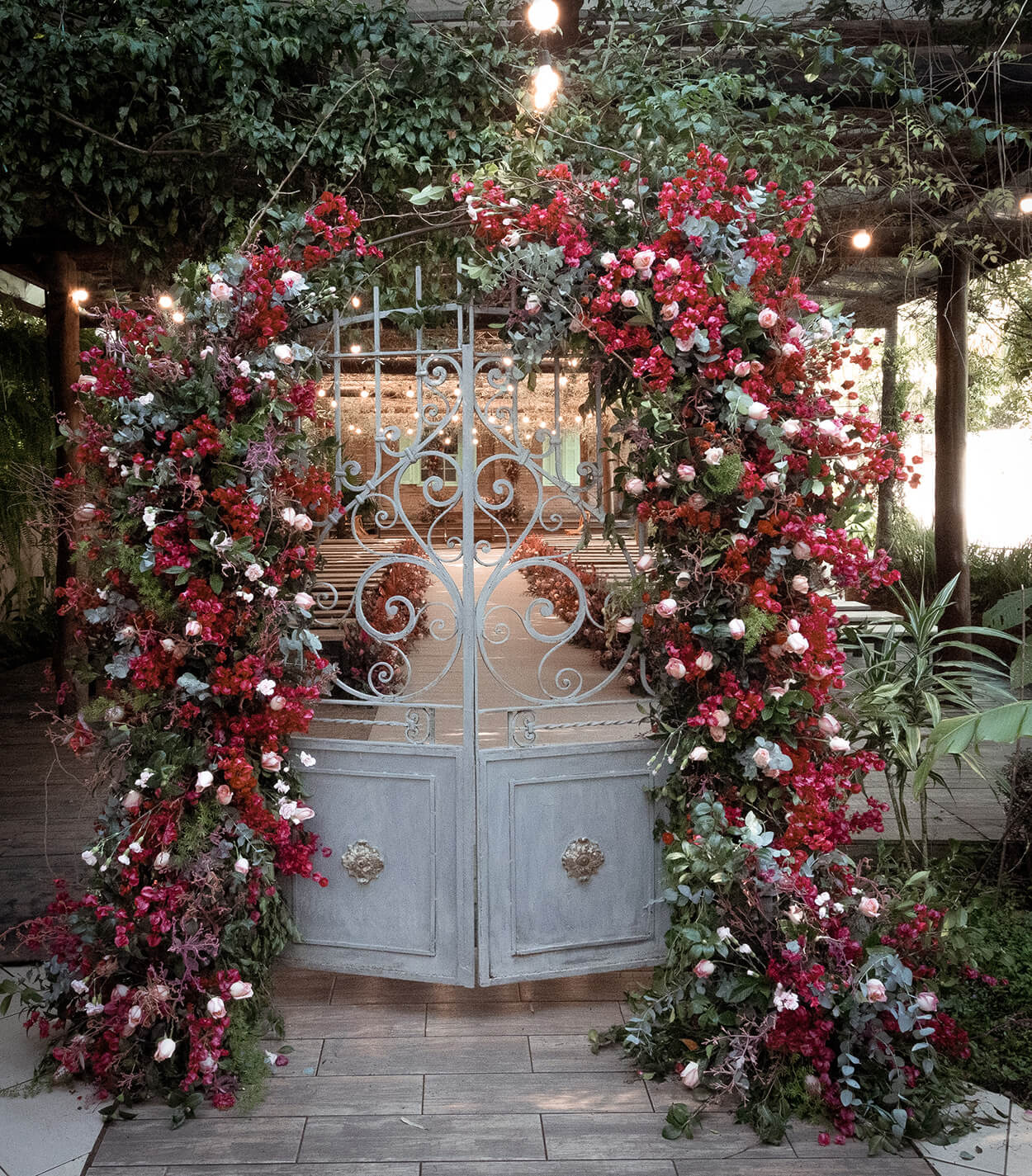 portão antigo azul coberto com flores rosas e brancas