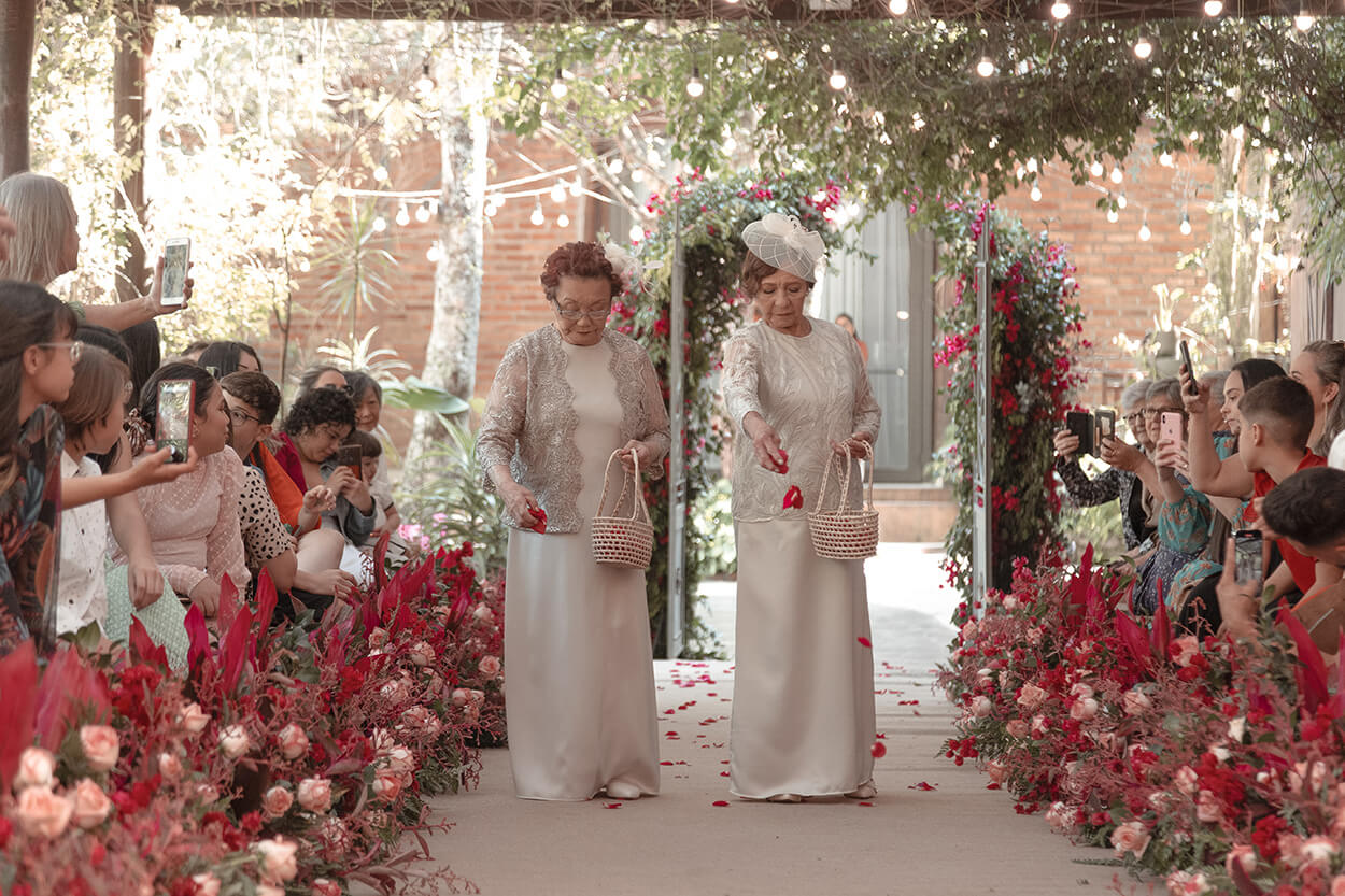 duas senhoras com vestidos bege entram como floristas no casamento