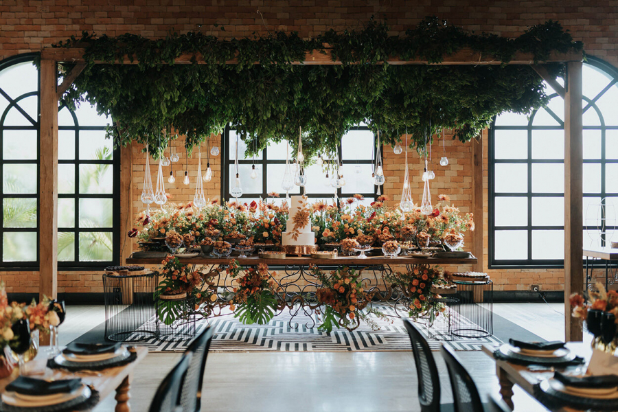 mesa do bolo com decoração de casamento rústico com arranjos suspensos