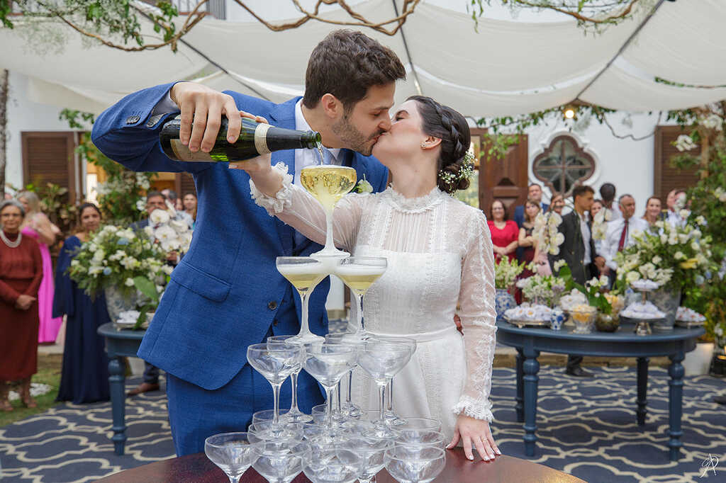 noivos se beijando e servindo champagne em torre de taças