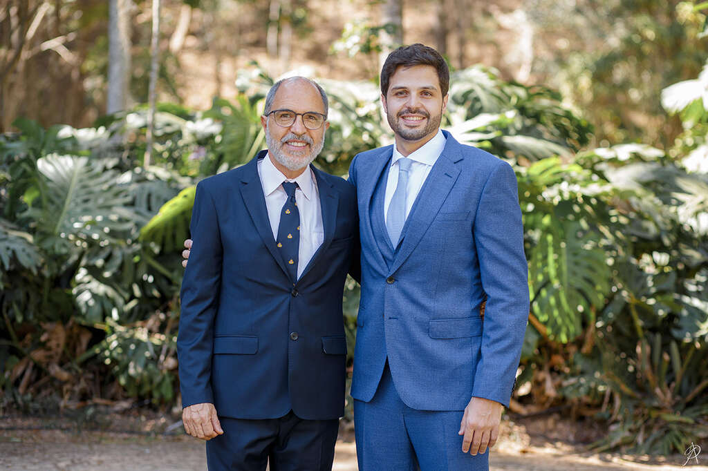 noivo com terno e gravata azul ao lado do pai com ttraje azul escuro