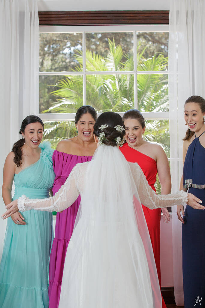 madrinhas com vestidos coloridos vendo a noiva no first look