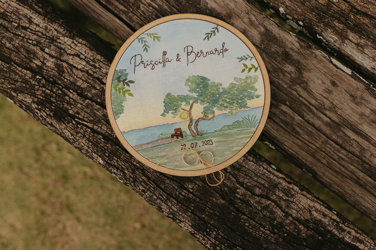porta aliança em bastidor com pintura de paisagem e escrito priscilla e bernardo