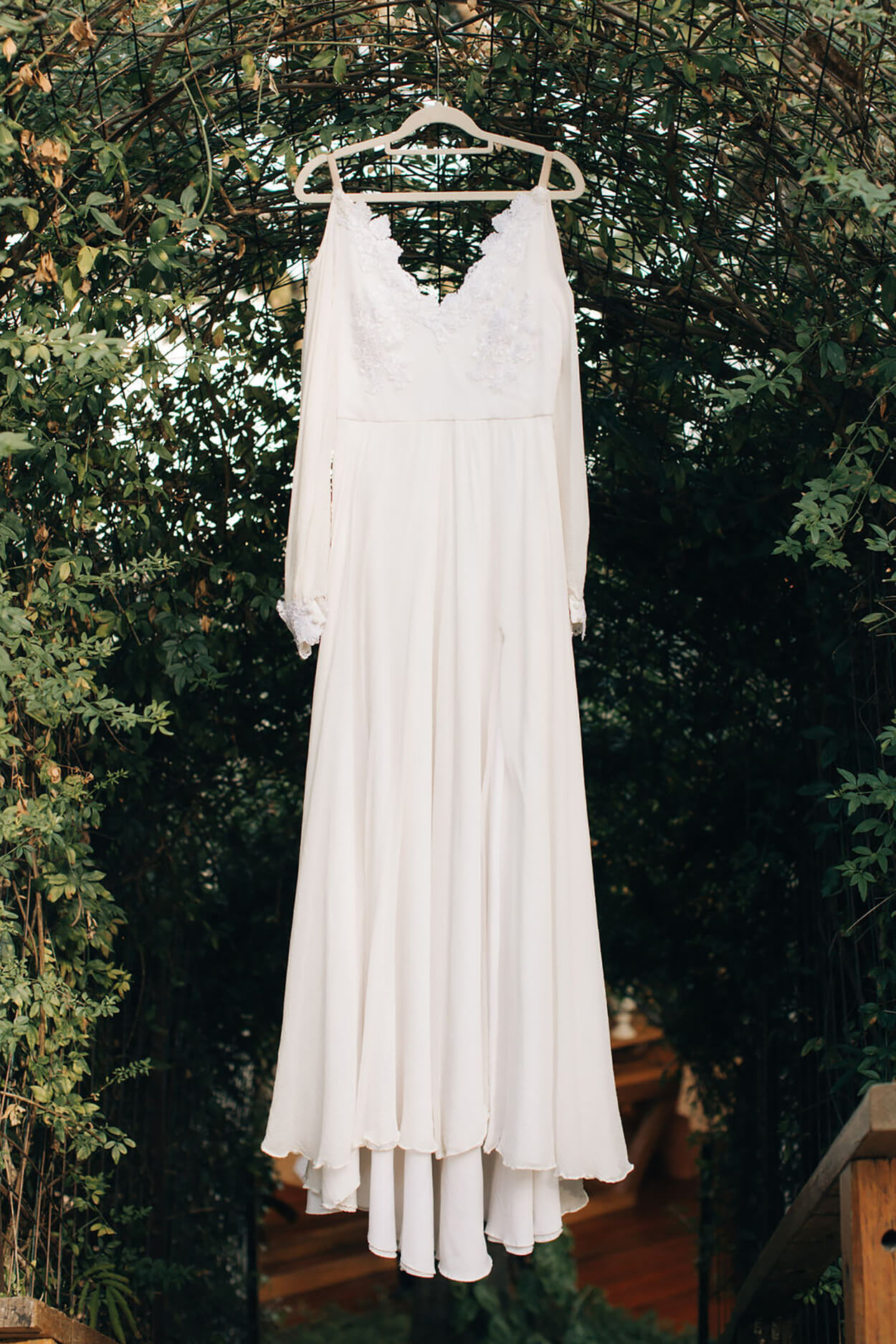 vestido de noiva com mangas pendurado no cabide ao ar livre