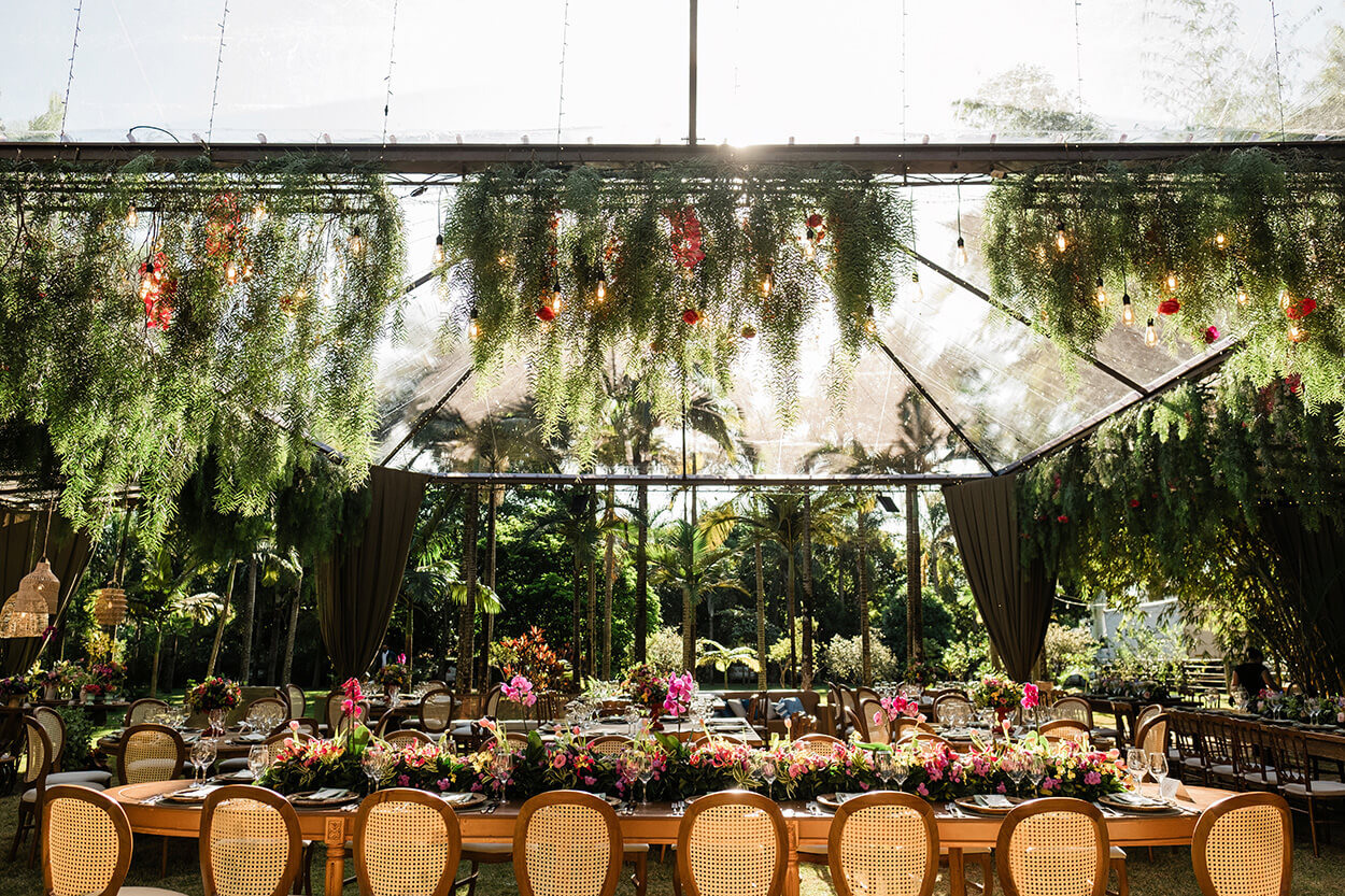 mesa de jantar com arranjos com flores coloridas e orquídeas rosas no centro da mesa