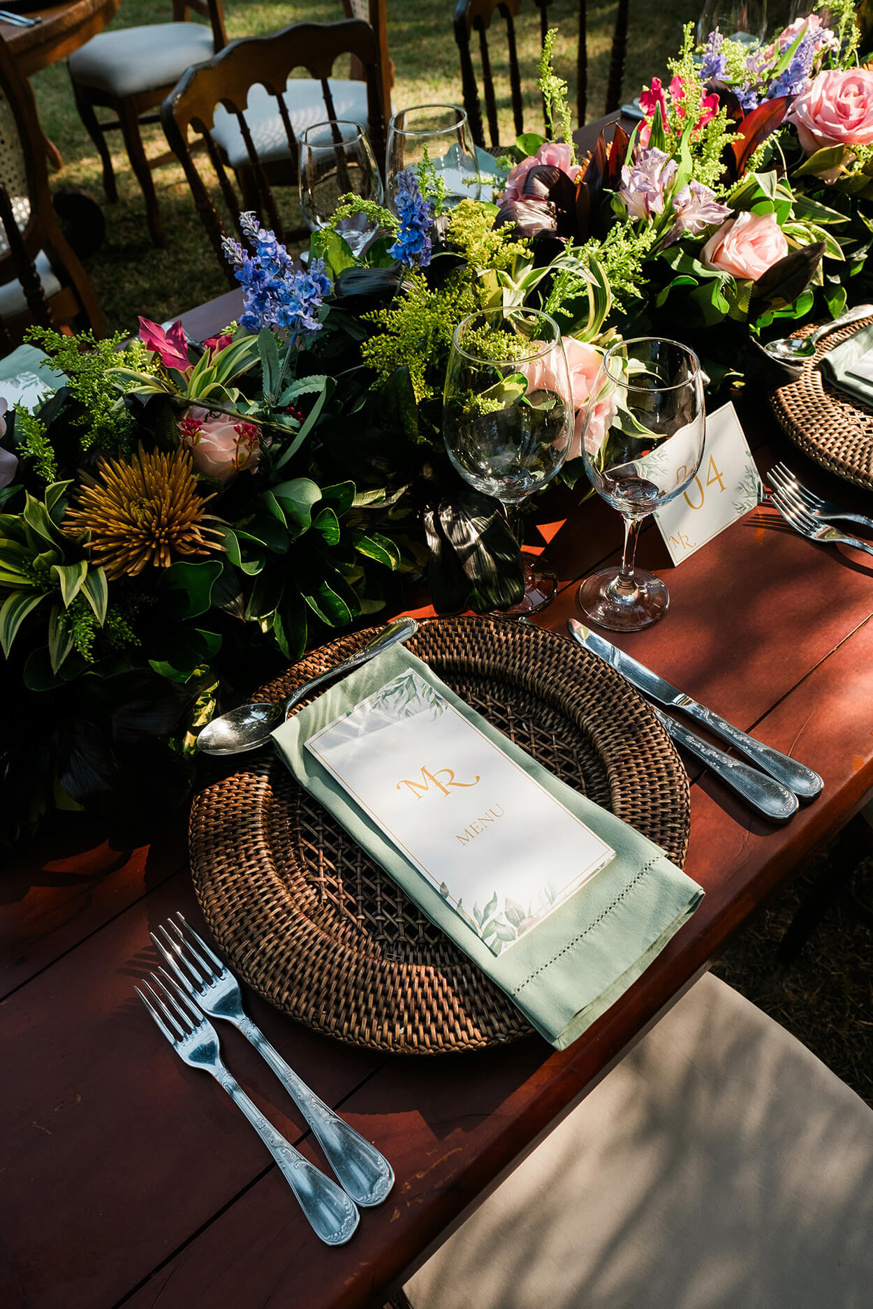 sousplat rústico com menu verde e branco e flores coloridas no centro da mesa