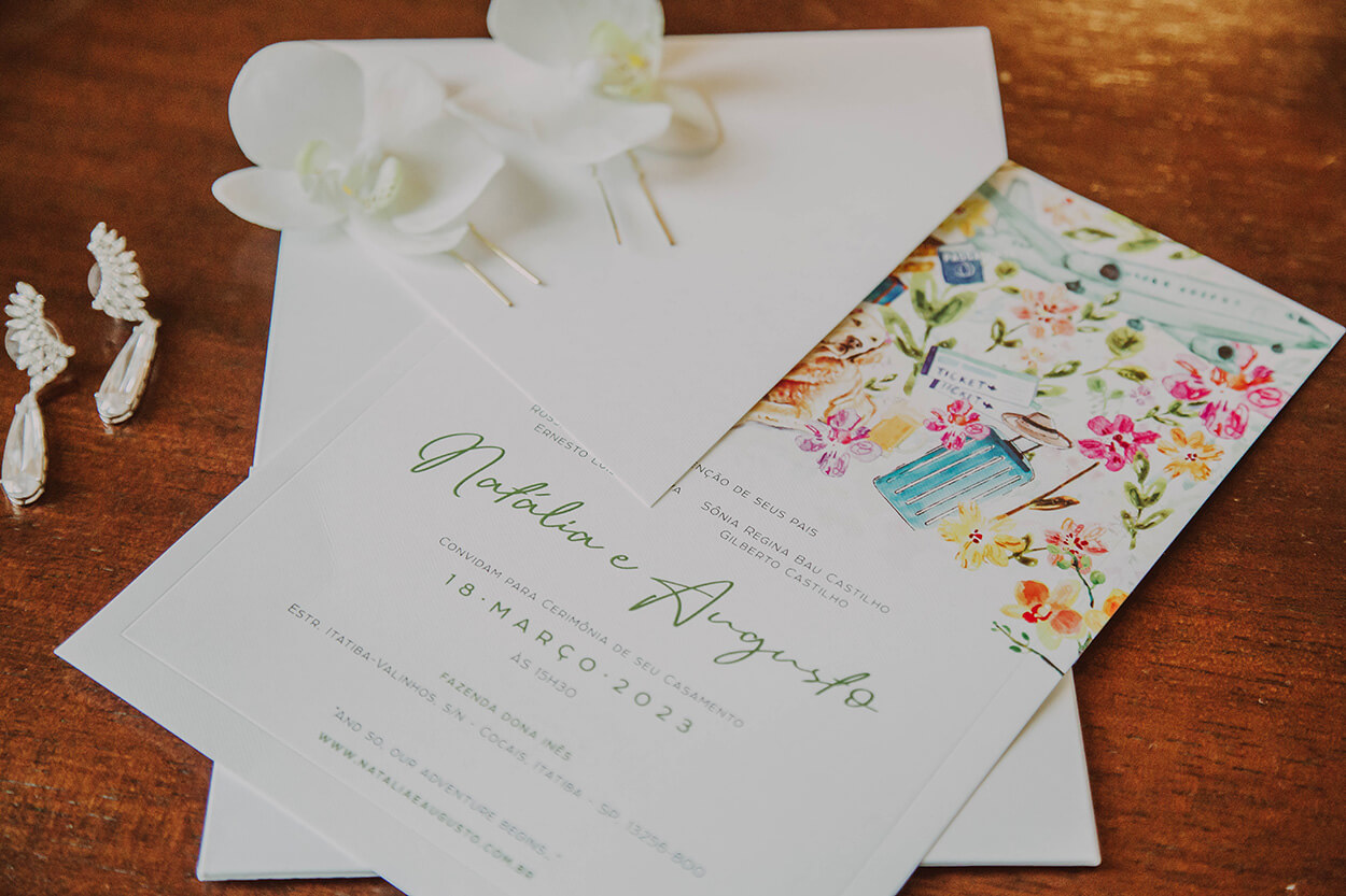 Convite de casamento com estampa de flores coloridas em cima da mesa 