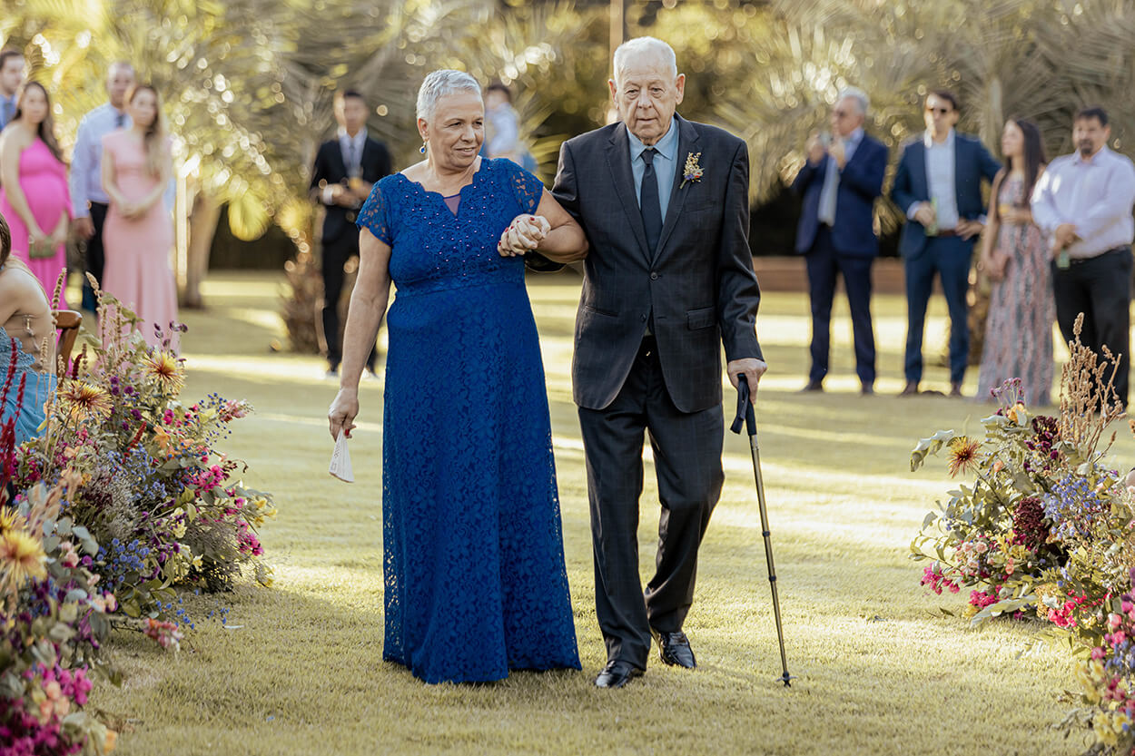 entrada dos avós da noiva a senhora com vetsido azul cobalto rendado longo e ele com terno cinza