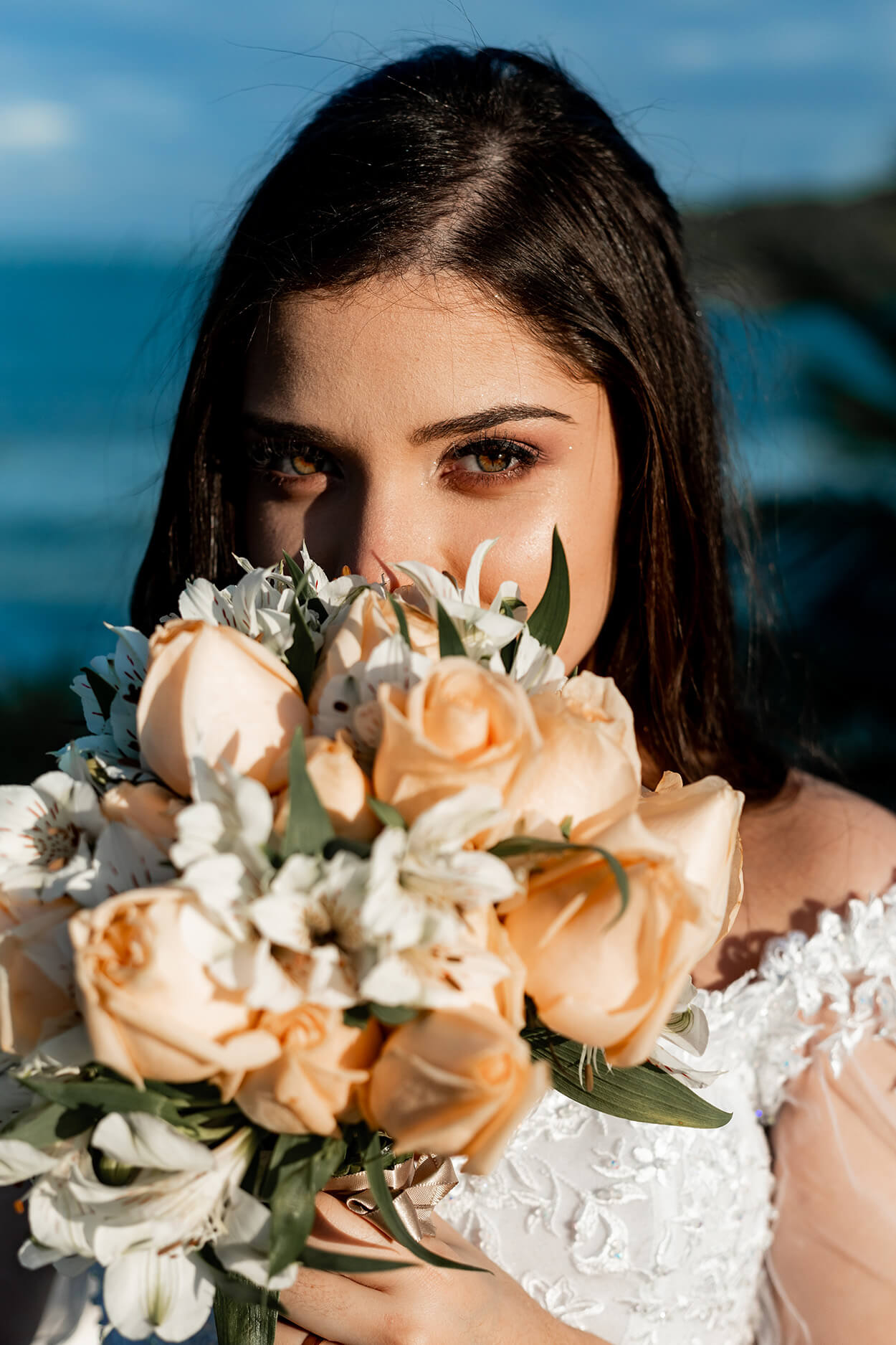 noiva segurando buquê redondo com flores brancas e rosas laranjas
