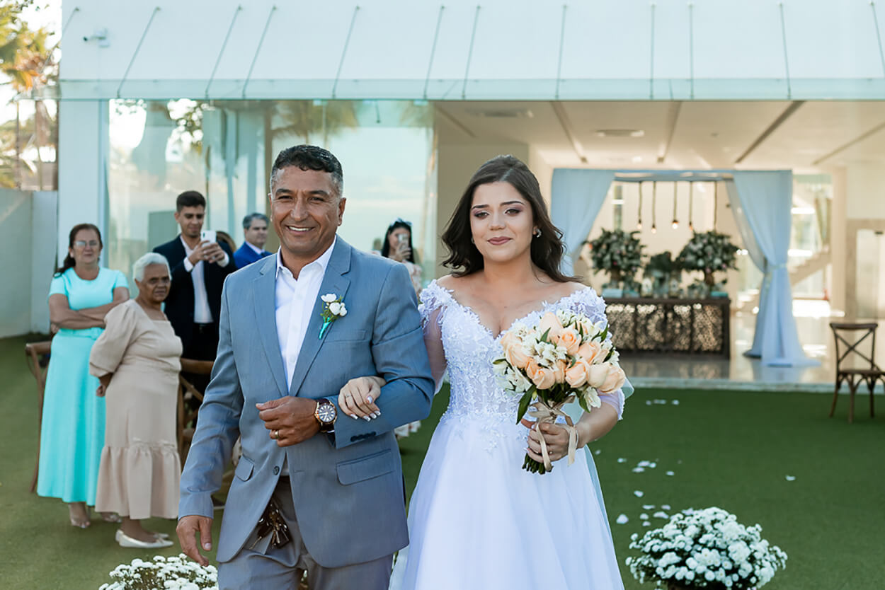 entrada da noiva emocionada com seu pai com terno cinza