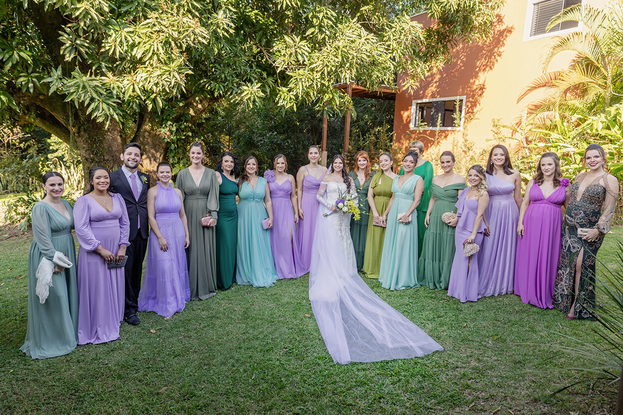 noiva ao lado das madrinhas com vestidos verdes e lilás