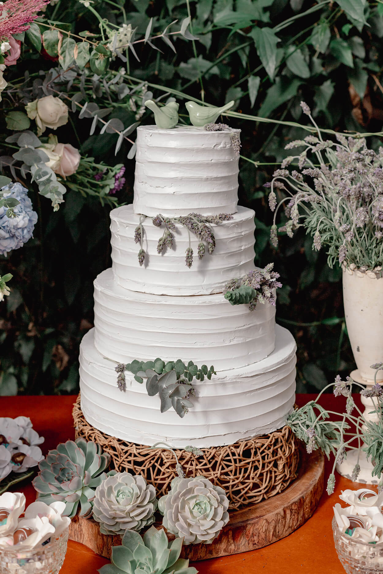 bolo de casamento branco com quatro andares e com ramos de lavanda