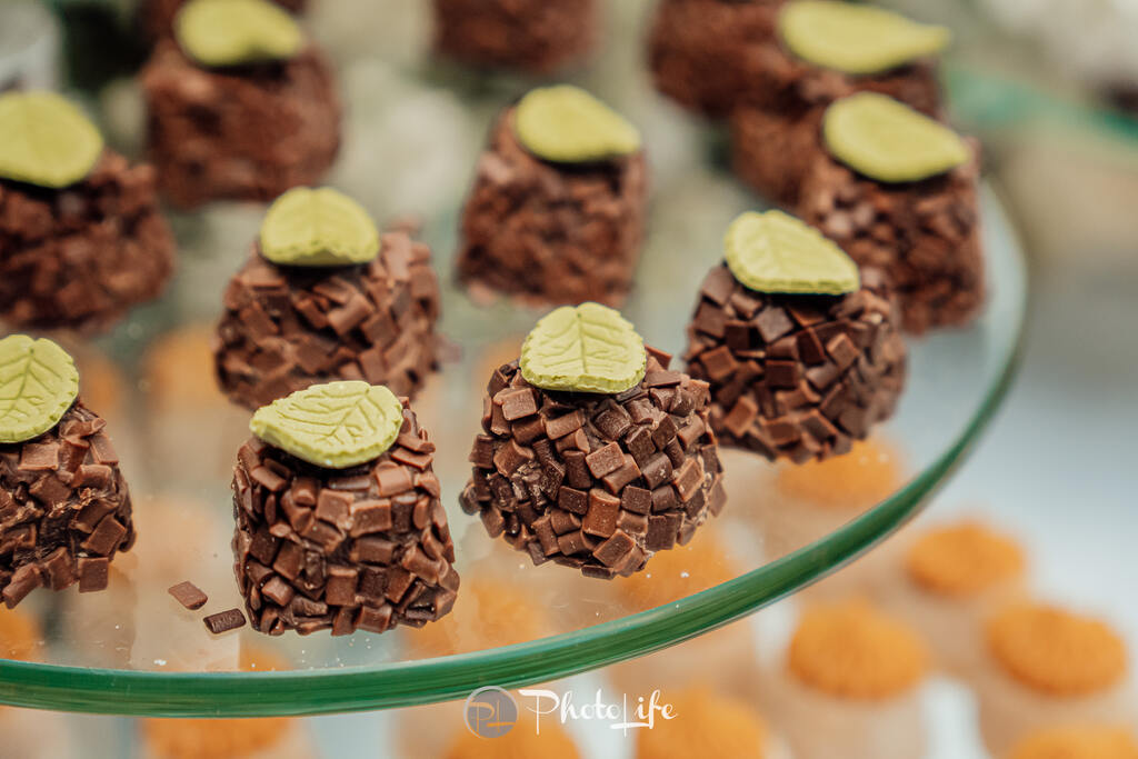 bandeja de vidro redonda com doces de chocolate com folha verde por cima