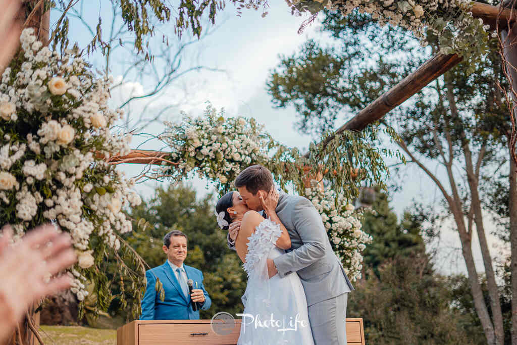 noivos se beijando no altar na cerimônia de casamento no campo