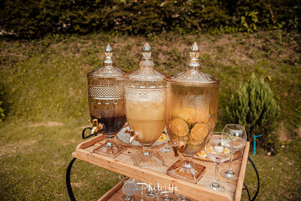 mesa de madeira no gramado com três suqueiras de vidro delicadas