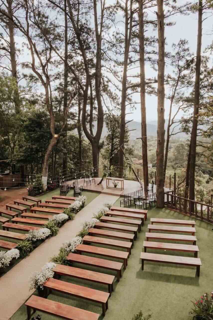 espaço ao ar livre para casamento rústico bancos de madeira de frente para pier com vista para as montanhas