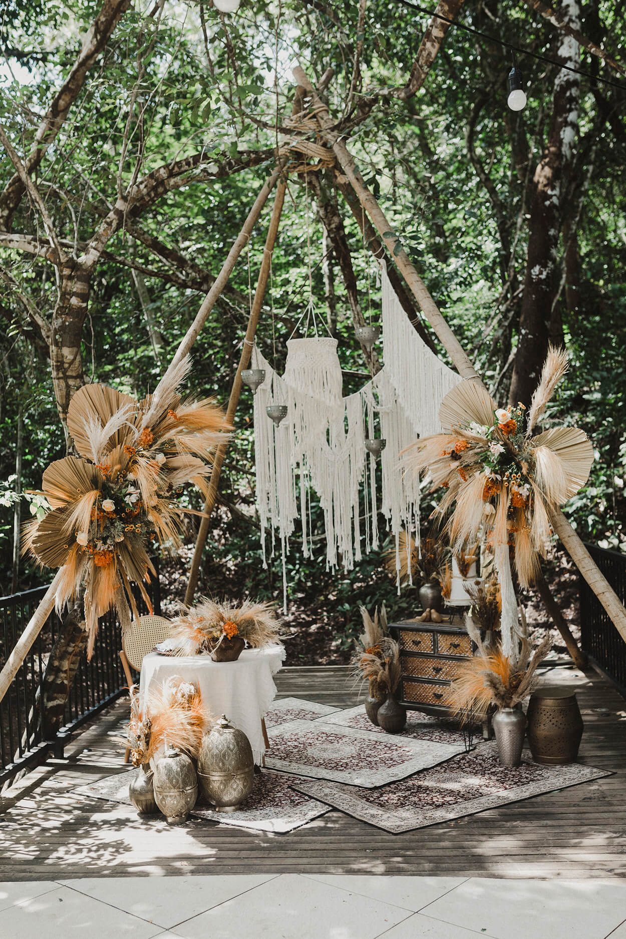 cabana de madeira com arranjos com folhas secas e capim dos pampas e macramê e mesa rústica