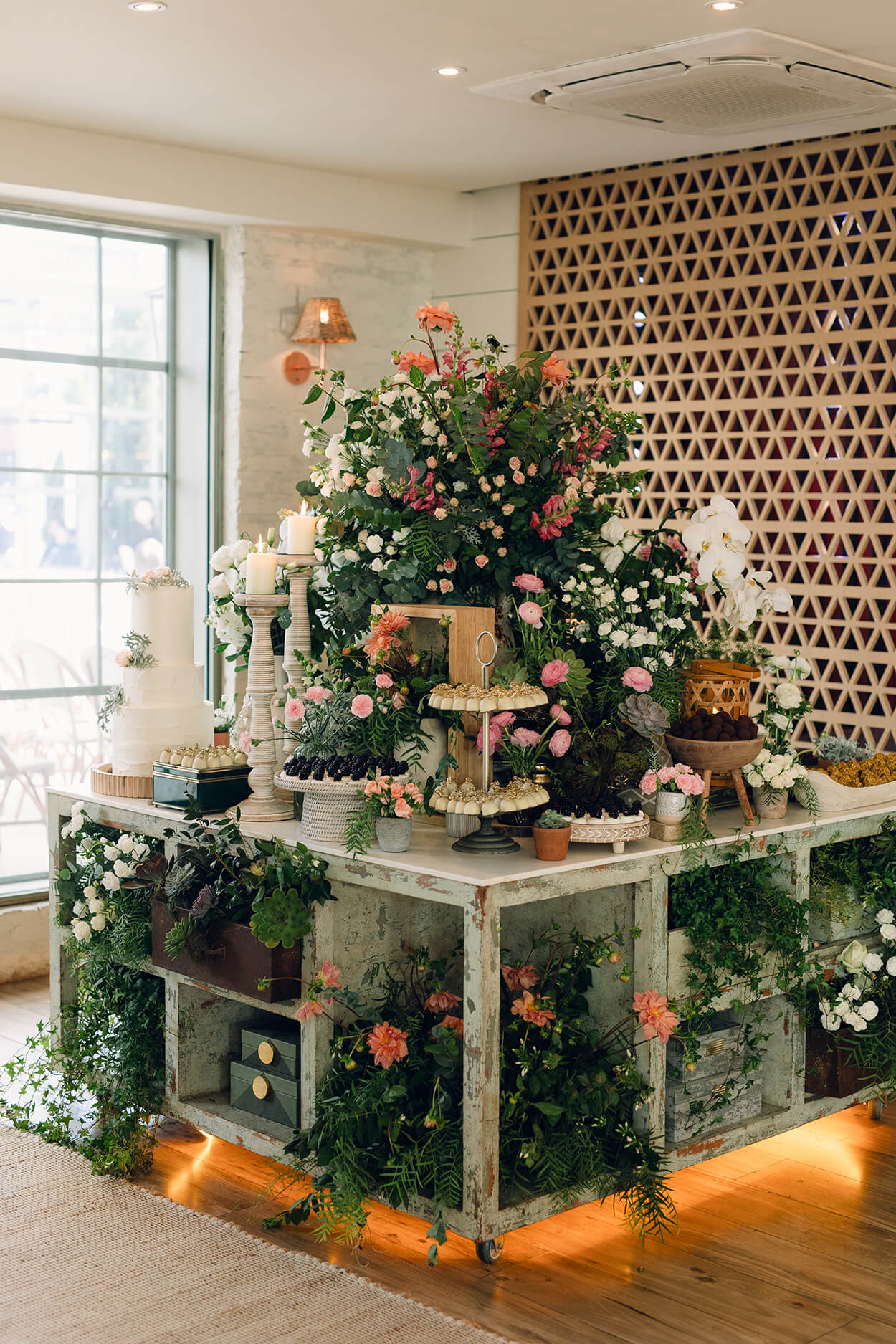 mesa com vasos deplantas e flores brancas e rosas