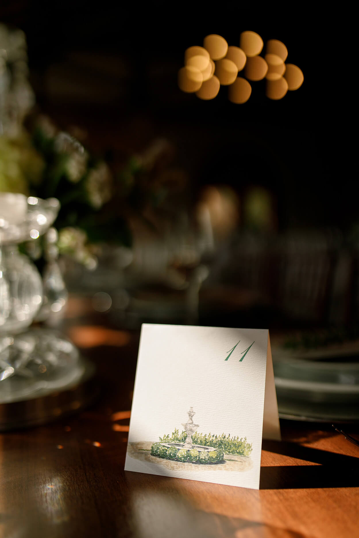marcador de mesa com papel com ilustração do espaço de casamento e número 11 no canto