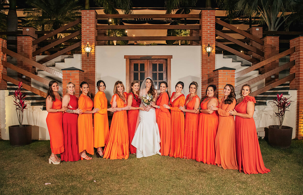 noiva ao lado das madrinhas com vestido laranja
