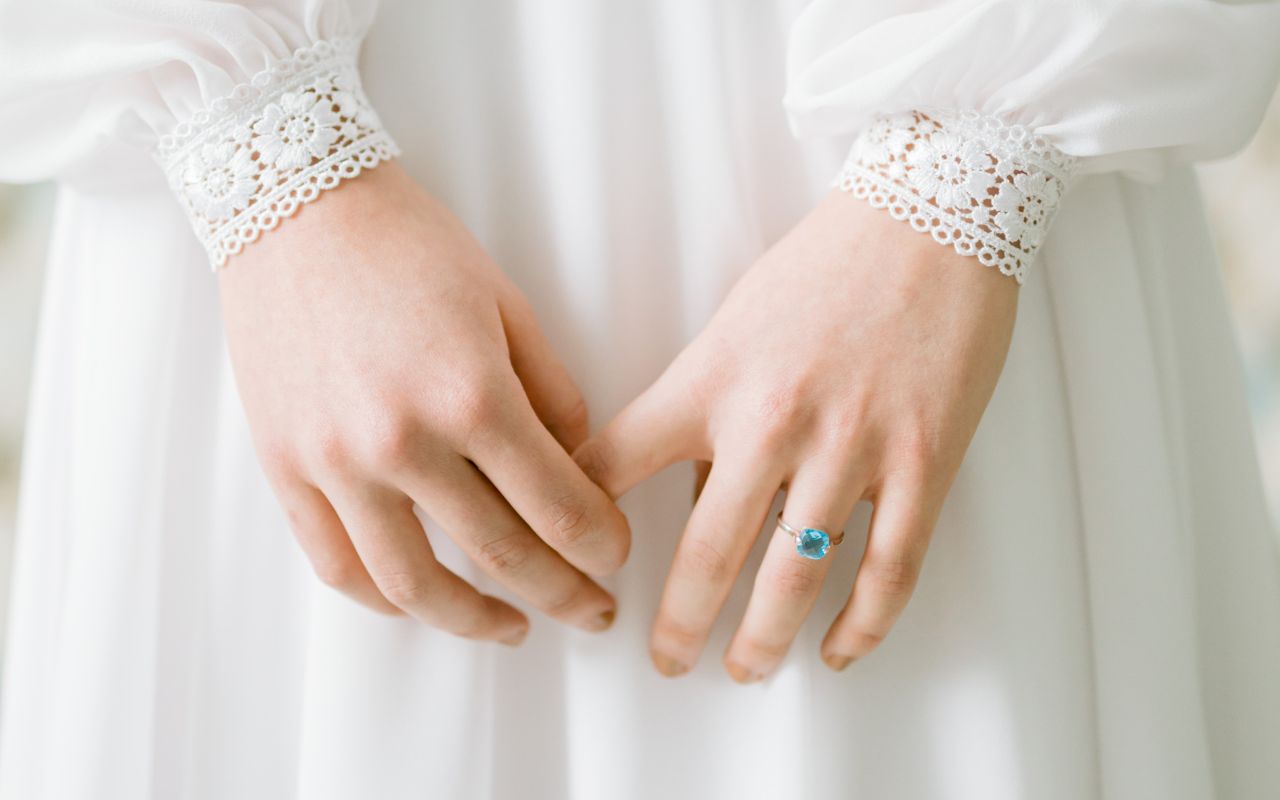 foto de mão de noiva com anel de pedra azul