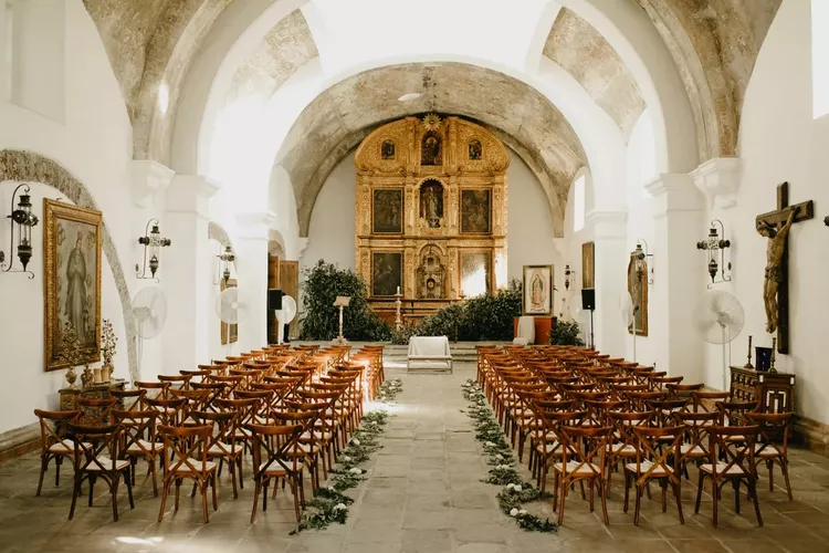 Decoração de igreja rústica com cadeiras de madeiras e vegetação