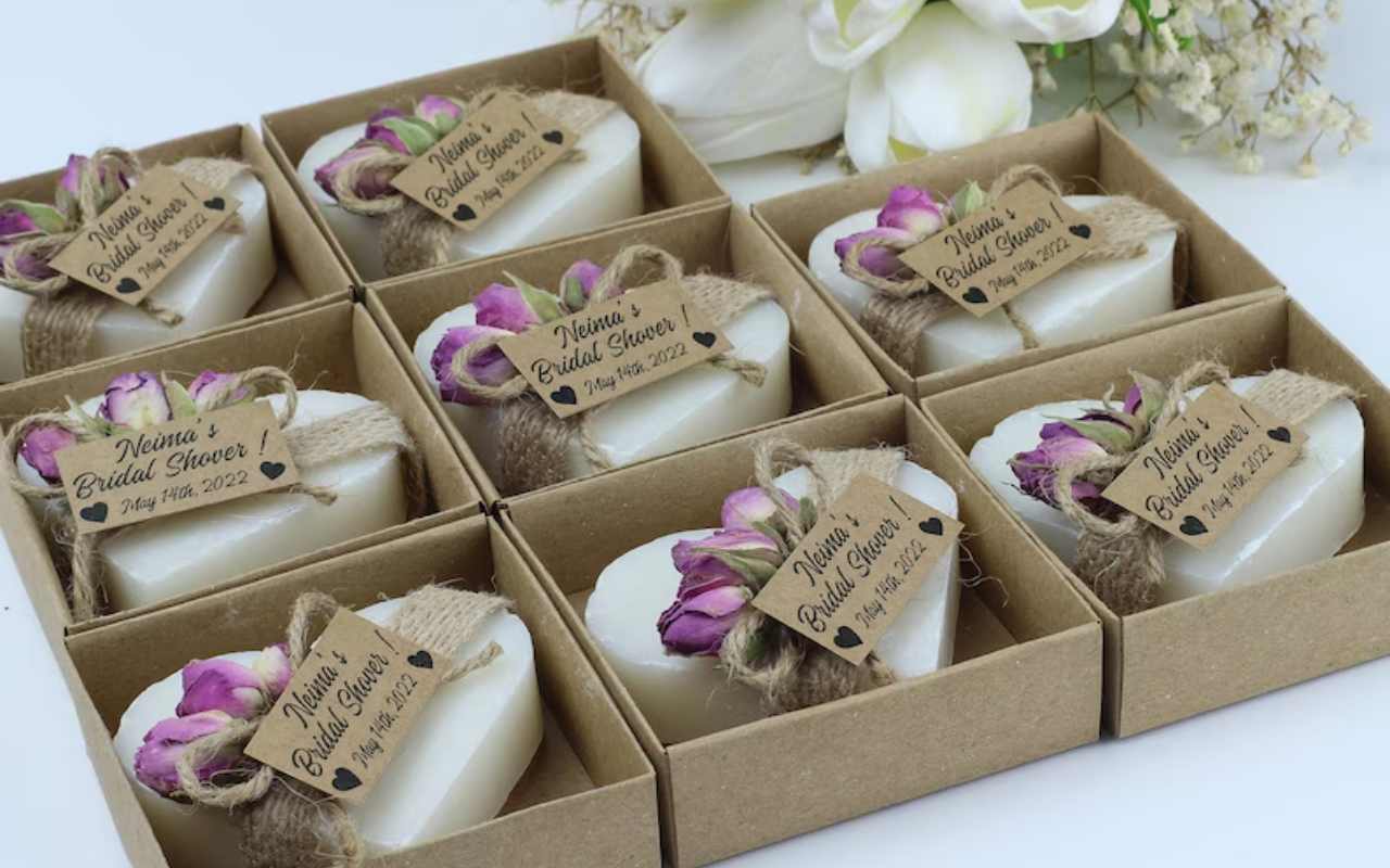 caixinhas quadradas de papelão com sabonetes em formato de coração com tag personalizada laço em juta e mini flor de lembrancinha para chá de panela