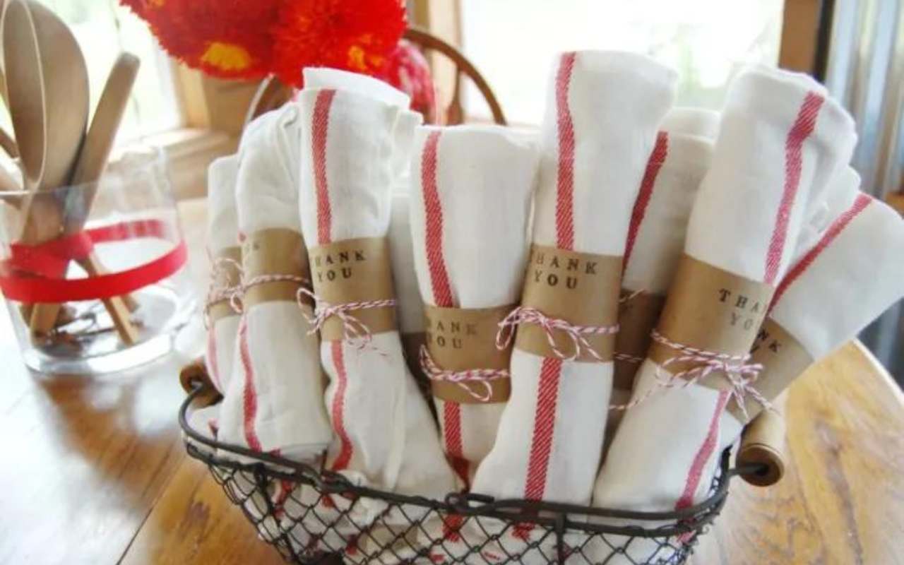 cesta com panos de prato em tecido enrolados para lembrancinha de chá de panela