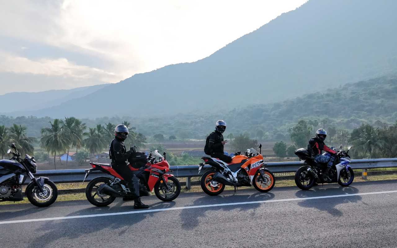quatro motos estacionadas na estrada com homens de jaqueta de couro