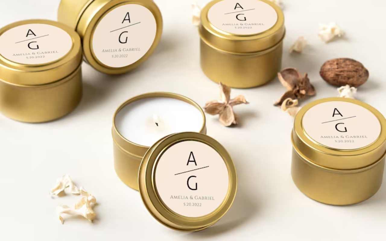 velas brancas dentro de latas douradas com rótulo personalizado para lembrancinha de chá de panela