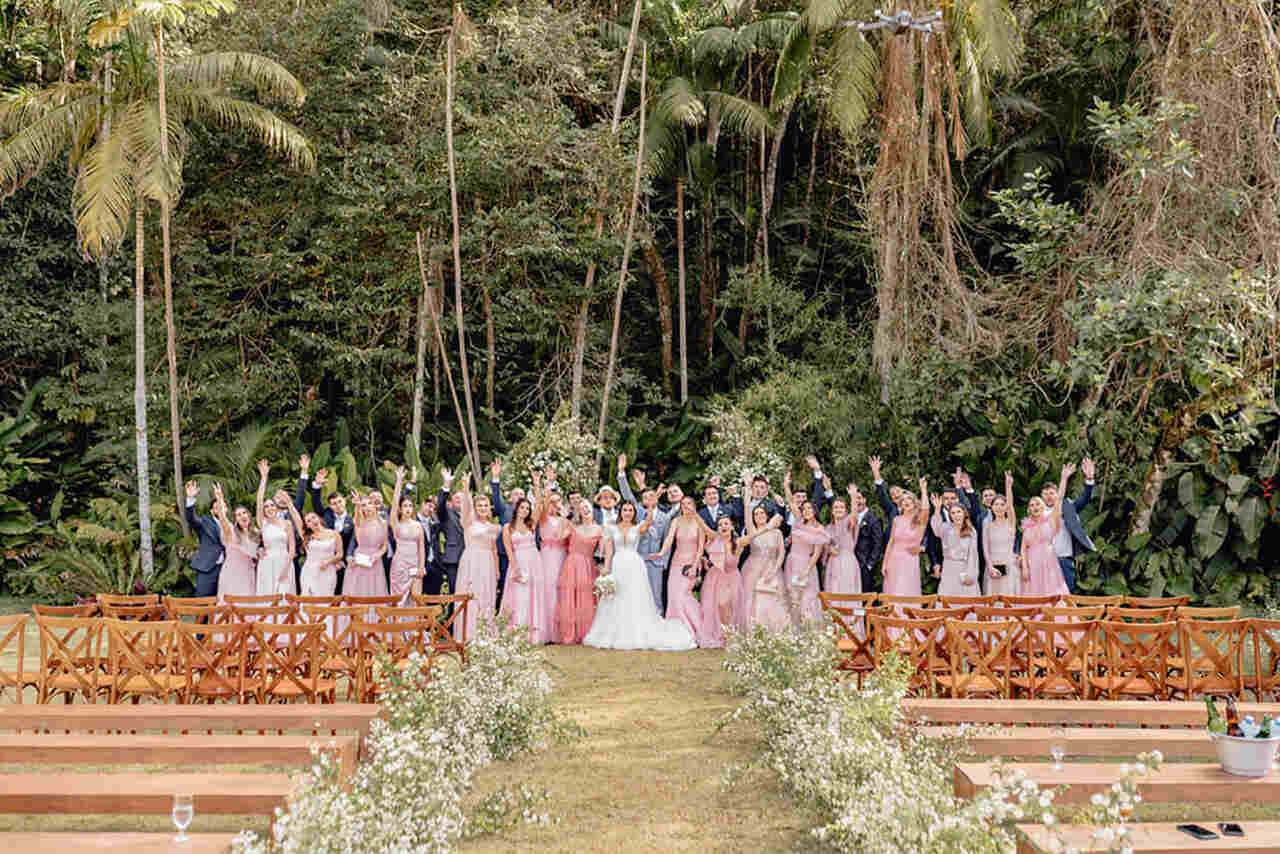 noivos ao lado das madrinhas com vestidos rose e padrinhos com terno azuis no sítio