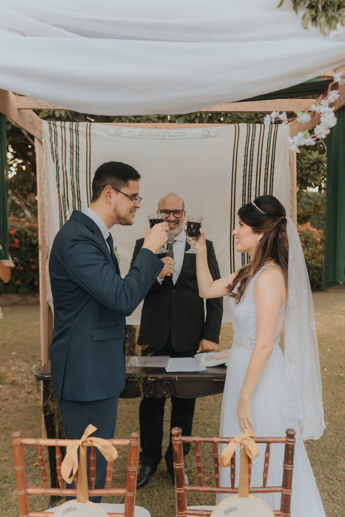 noivos brindando com taças de vinho na cerimonia de casamento judaico