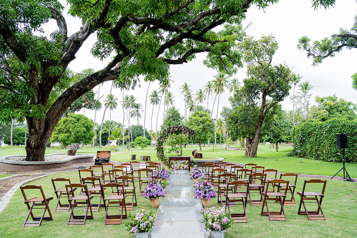 cadeiras de madeira com no jardim com altar com flores lilás 