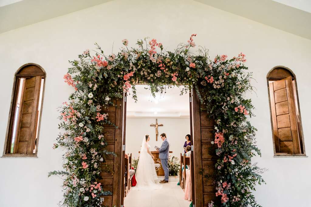 visão externa dos noivos no altar celebrando casamento clássico na igreja