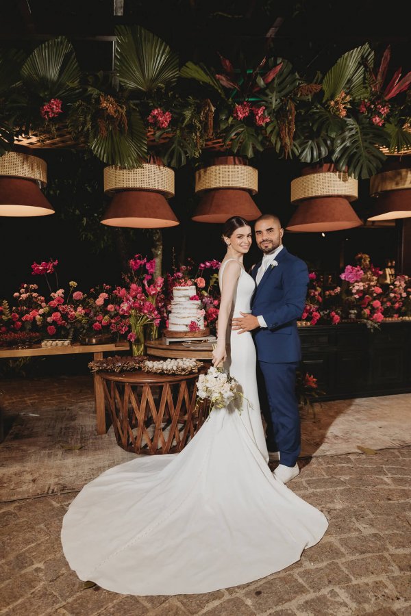 capa post: noivos na frente da mesa do bolo