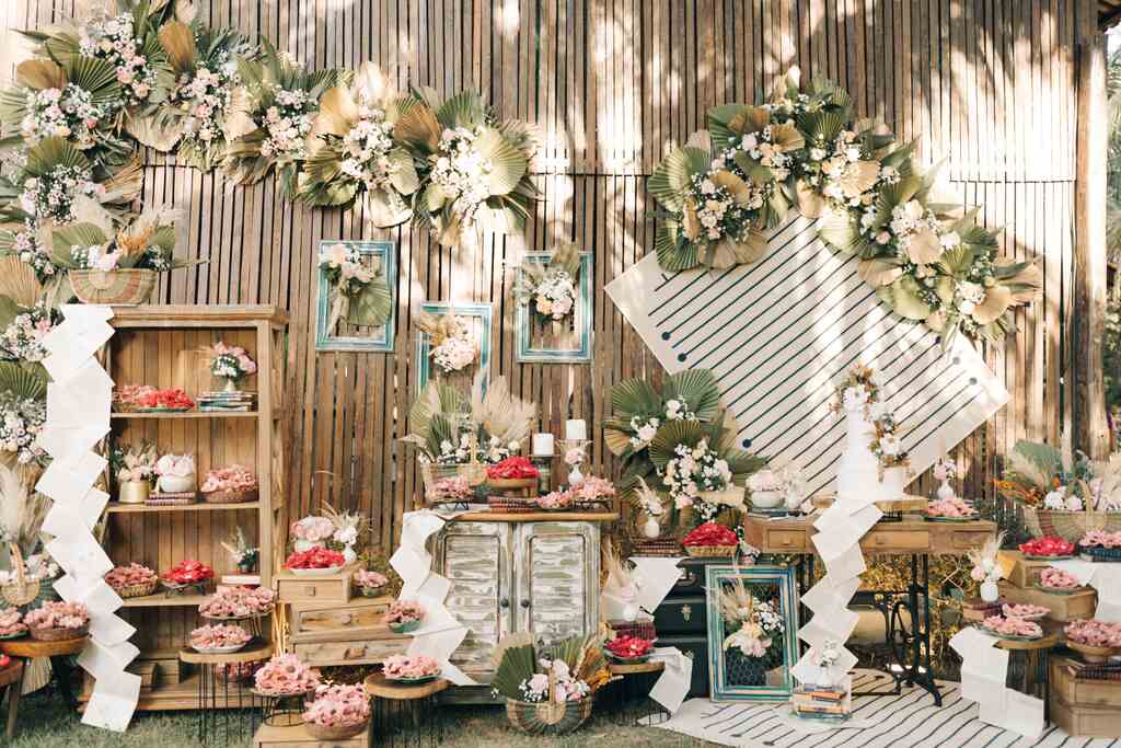 mesas e estantes de madeira com flores doces de casamento e vela