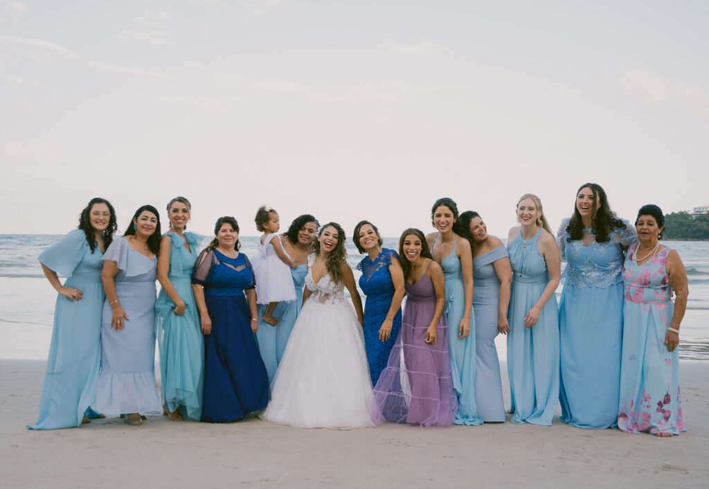 noiva ao lado das madrinhas com vestidos azuis serenity na praia